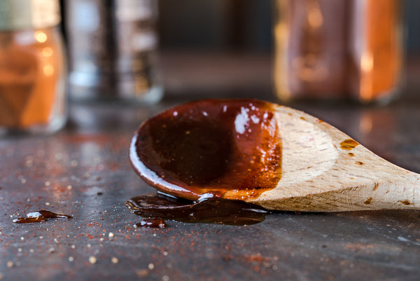 Pinot noir BBQ sauce for ribs on wooden spoon
